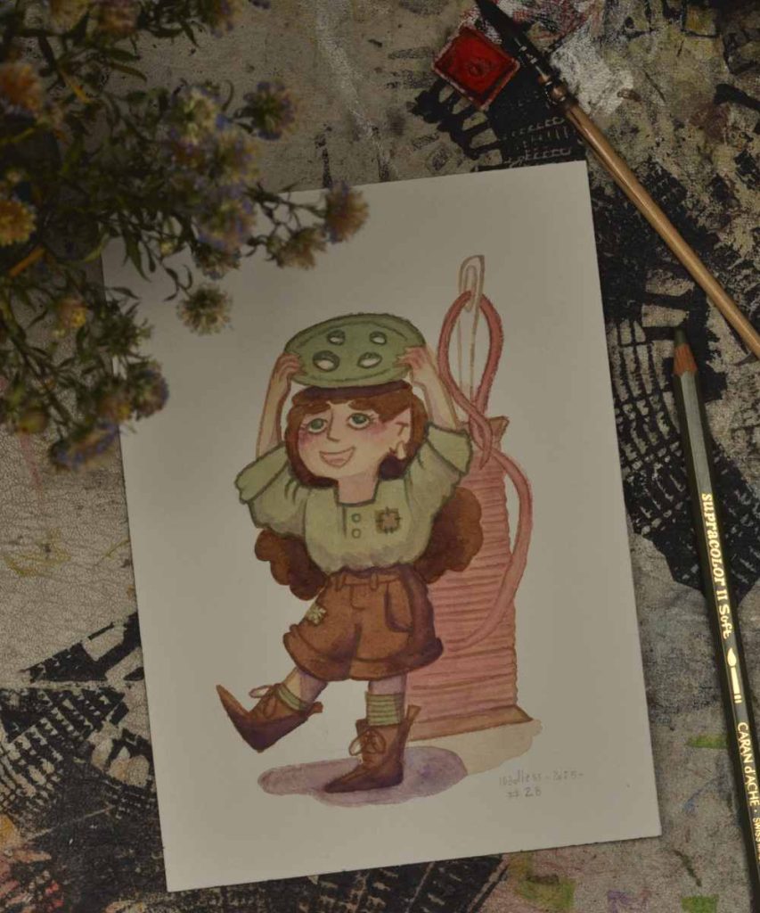 The photo of a watercolor illustration on a desk. The illustration shows a little person holding a green button over there head. The look very happy with their newfound treasure.