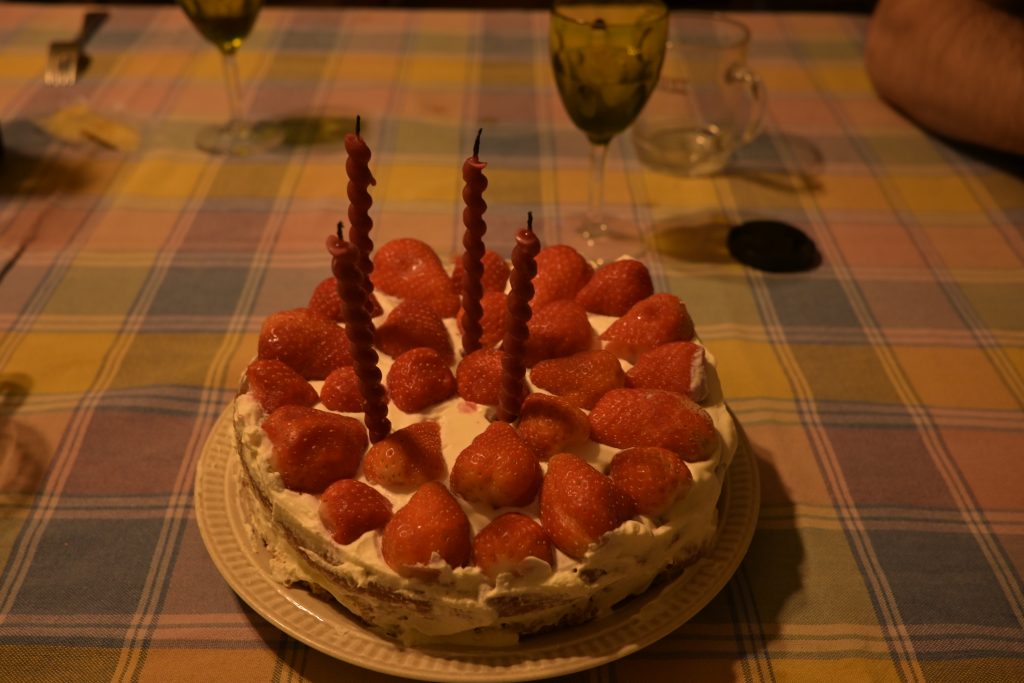 A strawbery cake with birthday candles