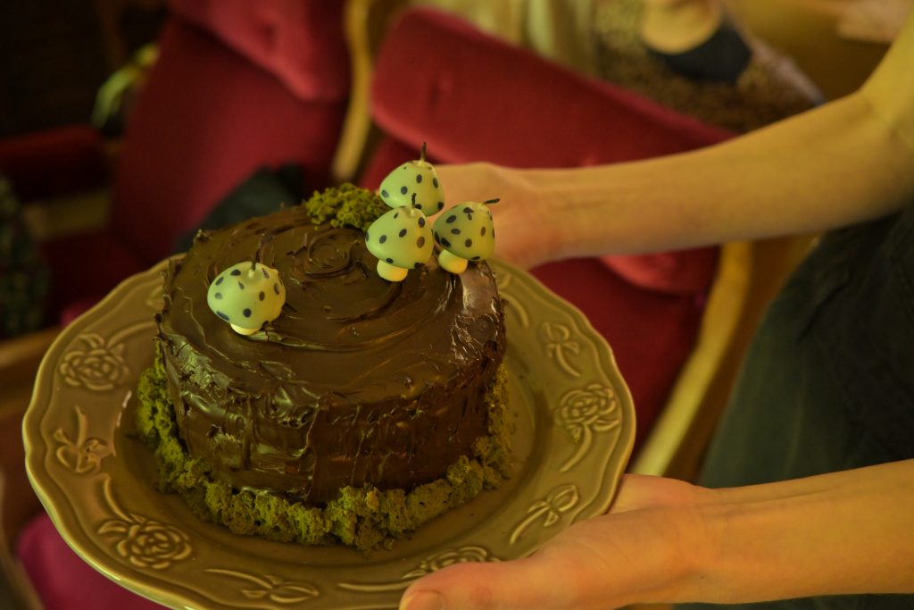 a Chocolate cake decorate with moss and mushroom candles